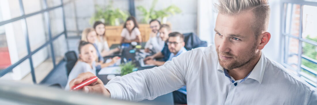 Business coach. Team leader teaches employees at a business meeting in a conference room.