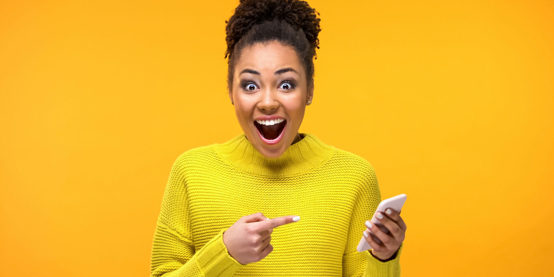 Joyful young woman pointing at smartphone in hand, online shopping application