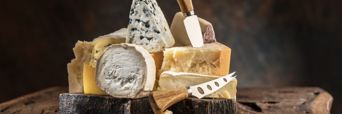 Assortment of different cheese types on wooden background. Cheese background.